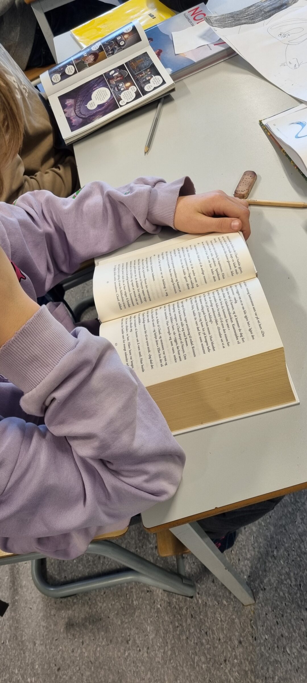 Bilde av elev som leser en tykk bok.
